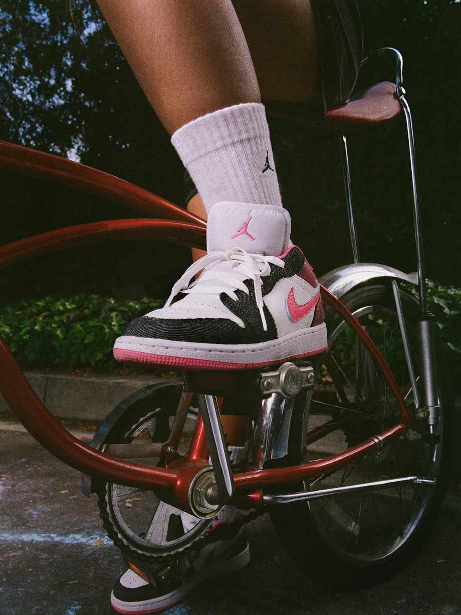 Young athlete balancing a basketball shoe on a bicycle pedal