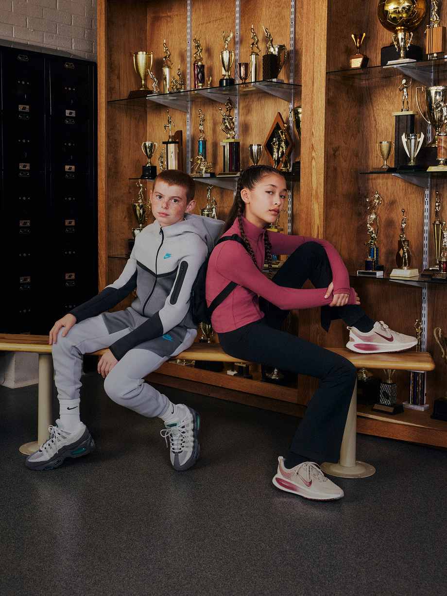Two young athletes in a locker room wearing performance apparel